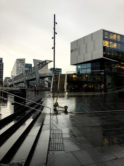 穿黑夹克的人白天走在人行道上